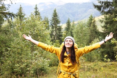 Photo of Young hiker with backpack in forest near mountains. Active tourism