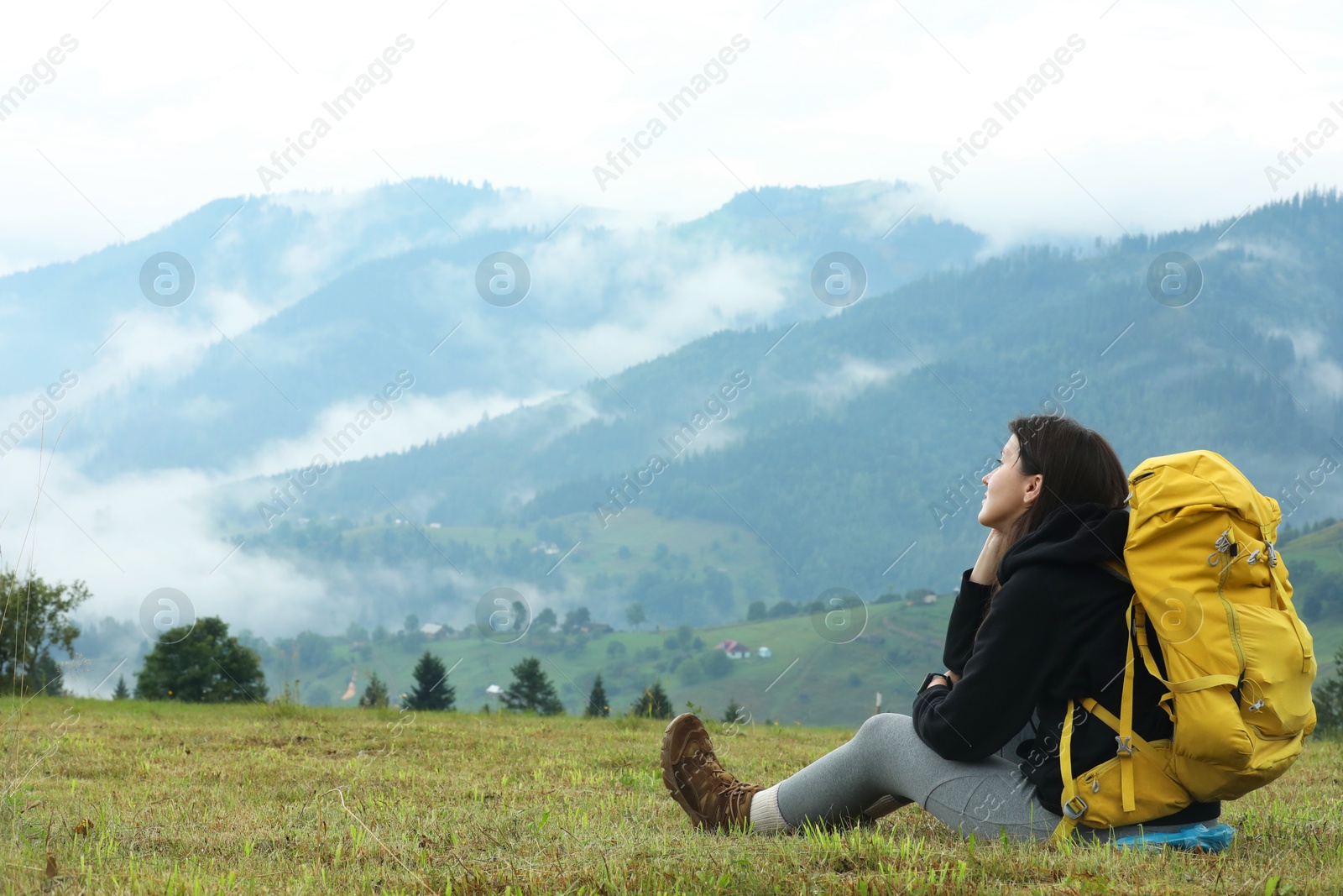 Photo of Young hiker with backpack in mountains. space for text