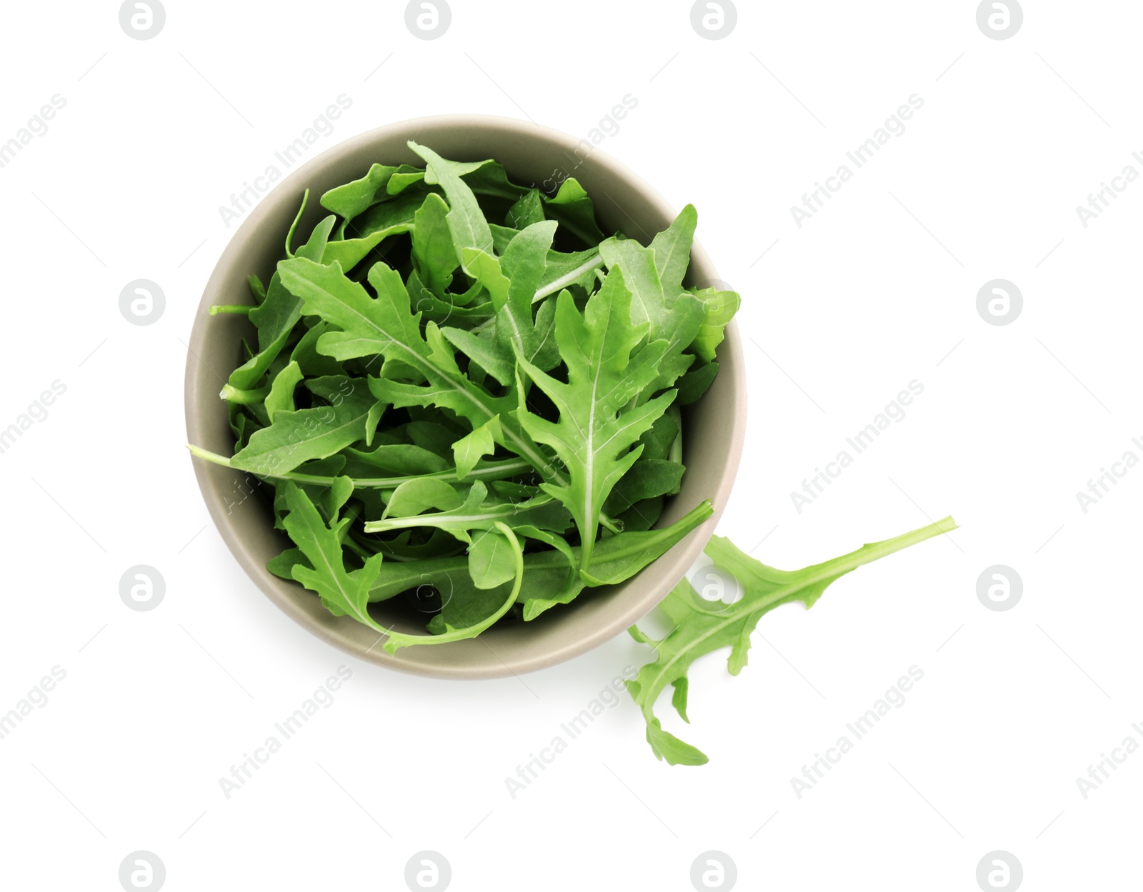 Photo of Fresh arugula leaves in bowl isolated on white, top view