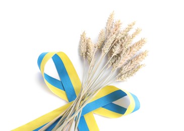 Photo of Ears of wheat with ribbon in colors of Ukrainian national flag isolated on white