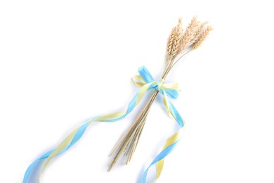 Photo of Ears of wheat with ribbons in colors of Ukrainian national flag isolated on white, top view