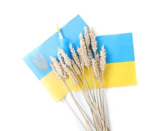 Ears of wheat and Ukrainian national flag isolated on white, top view