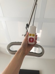 Photo of Woman with remote controller in hospital ward, low angle view