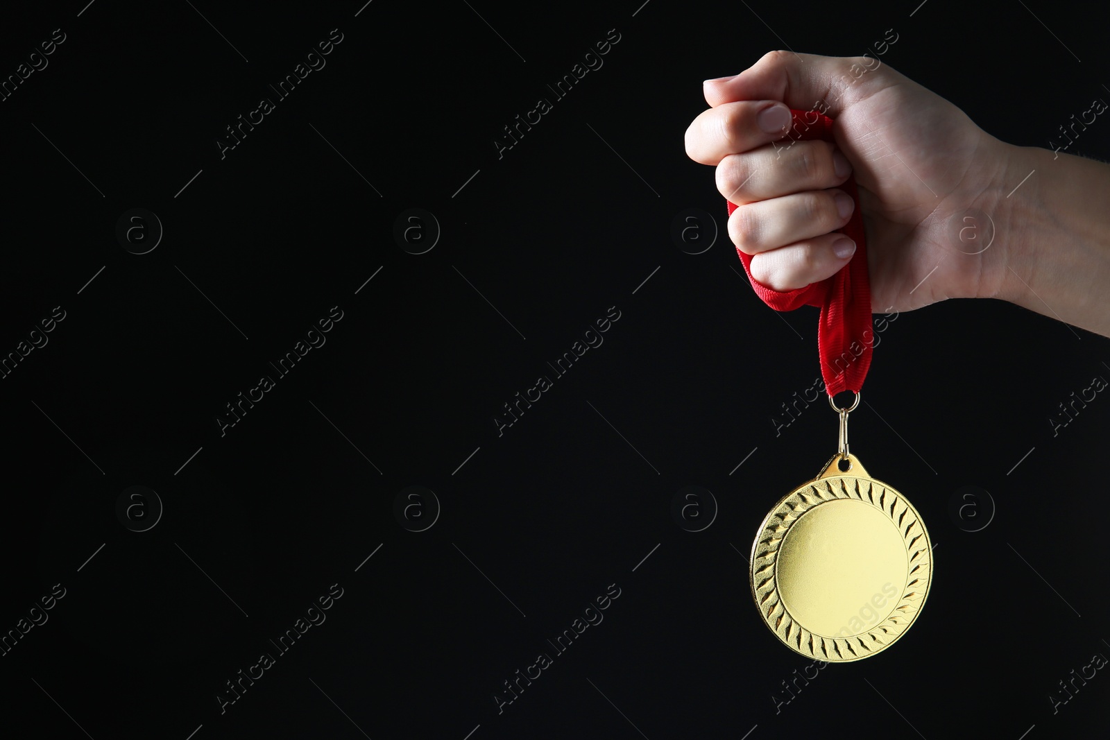 Photo of Woman with golden medal on black background, closeup. Space for text