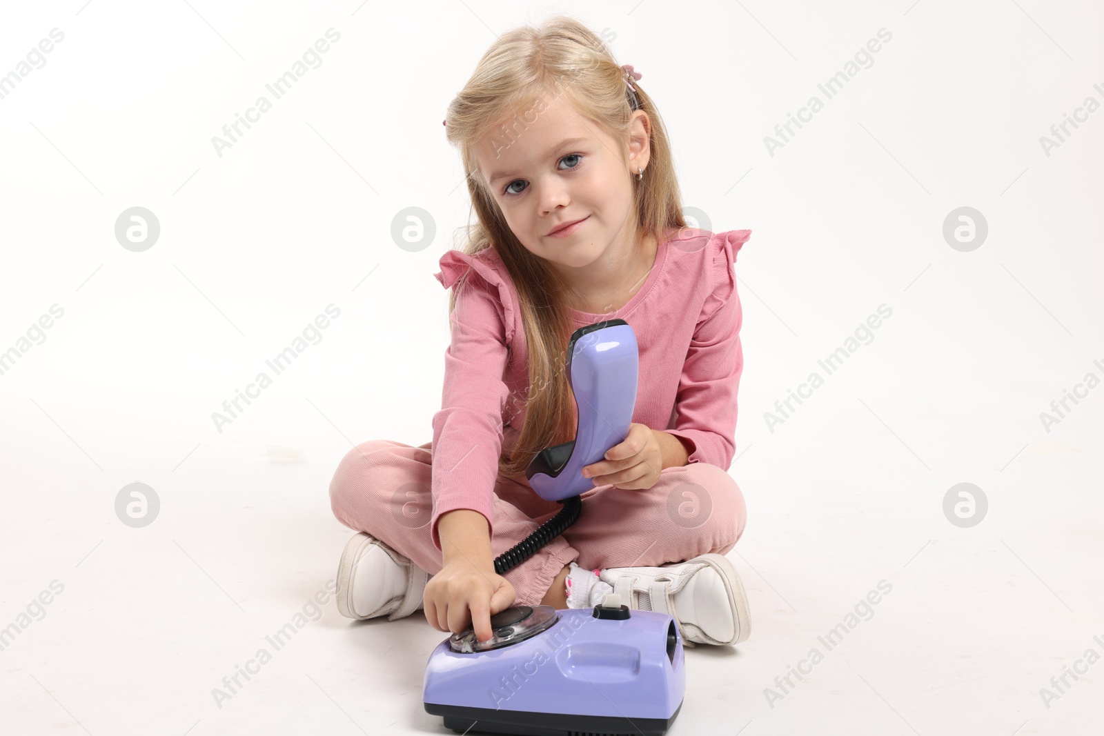 Photo of Cute little girl with telephone on white background