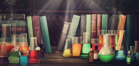 Image of Chemist's workplace with old books and laboratory glassware, vintage style. Banner design