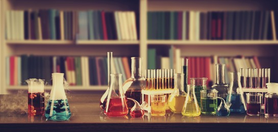 Image of Chemist's cabinet with laboratory glassware and shelves full of books, vintage style. Banner design