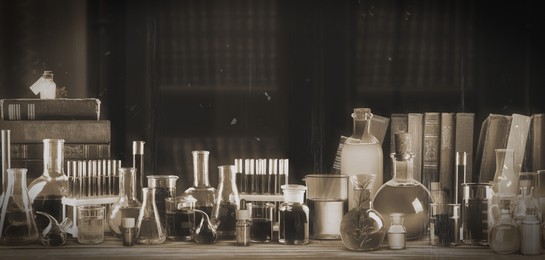 Image of Chemist's workplace with old books and laboratory glassware, vintage style. Banner design