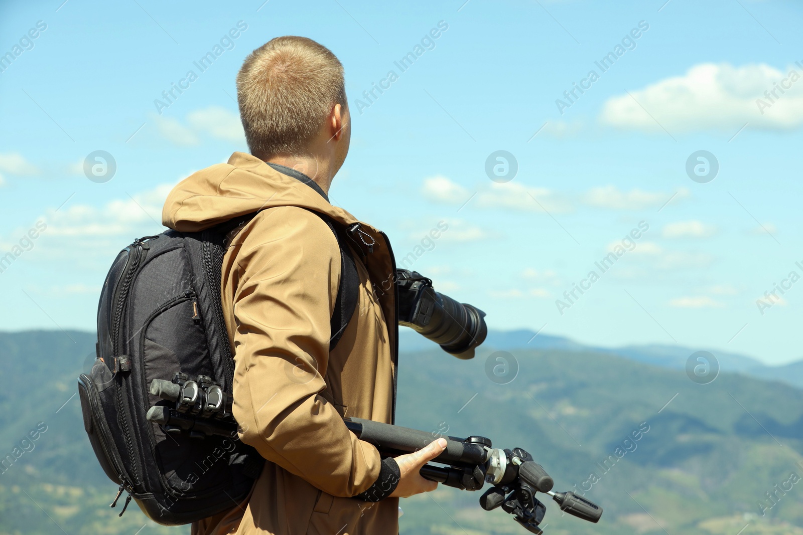 Photo of Photographer with backpack, camera and other professional equipment in mountains