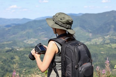 Photographer with backpack and camera in beautiful mountains