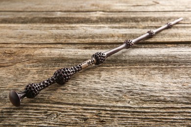 Photo of One old magic wand on wooden table, closeup