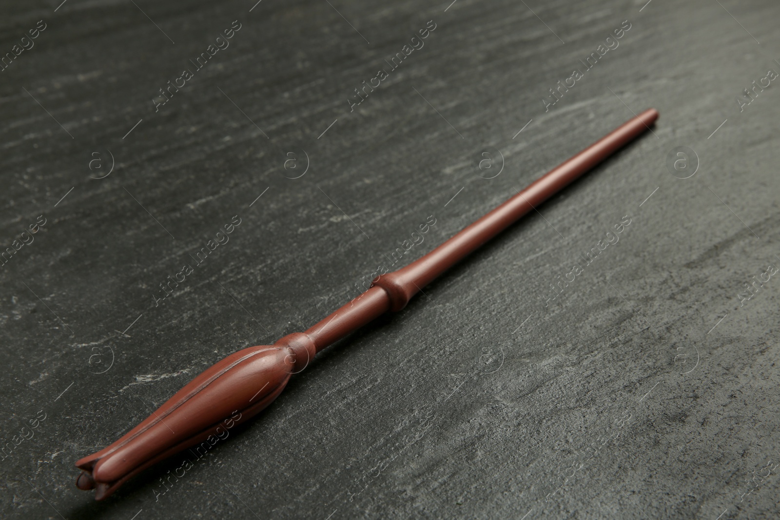 Photo of One old magic wand on black table, closeup