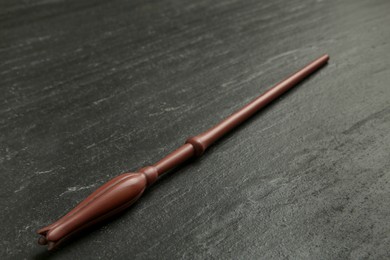 Photo of One old magic wand on black table, closeup