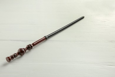 Photo of One old magic wand on white wooden table