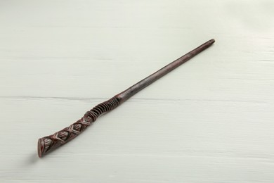 Photo of One old magic wand on white wooden table, closeup