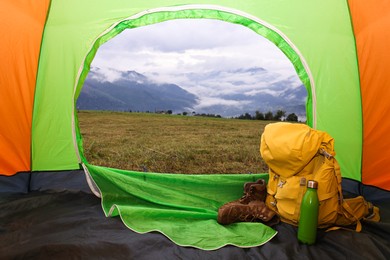 Photo of Picturesque view of mountain from tent with camping equipment