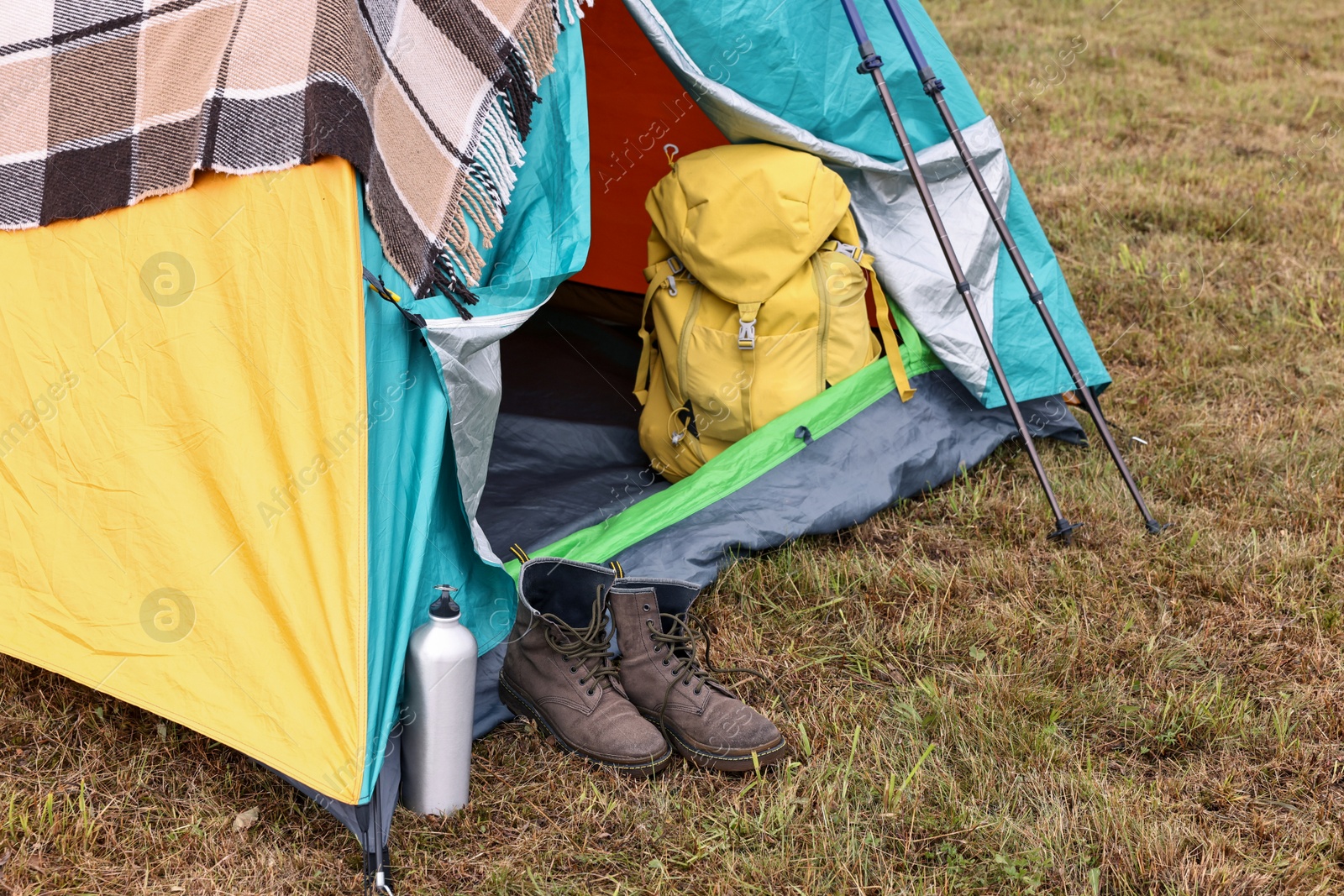 Photo of Camping tent and tourist stuff on grass outdoors