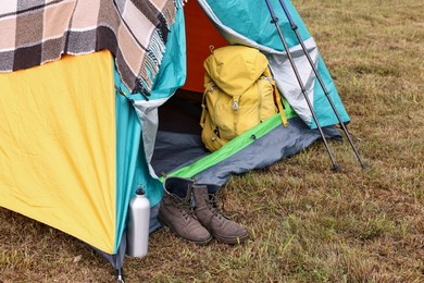 Camping tent and tourist stuff on grass outdoors