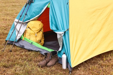 Photo of Camping tent and tourist stuff on grass outdoors