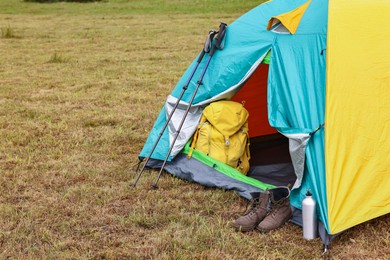 Photo of Camping tent and tourist stuff on grass in mountains, space for text