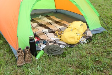 Tent and camping equipment on green grass outdoors