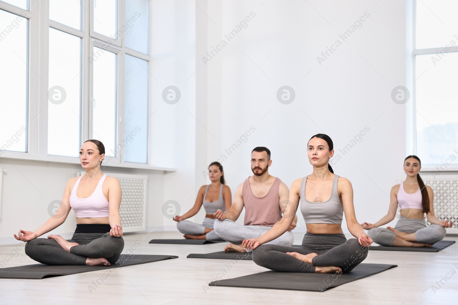 Photo of Group of people meditating on mats in yoga class