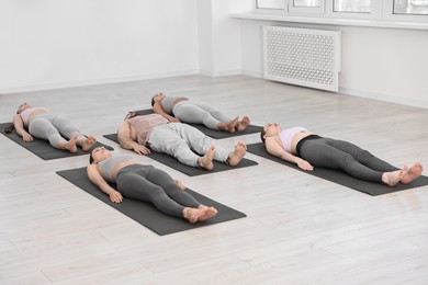 Photo of Group of people meditating on mats in yoga class