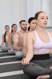 Group of people meditating on mats in yoga class