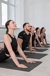 Photo of Group of people practicing yoga on mats in class