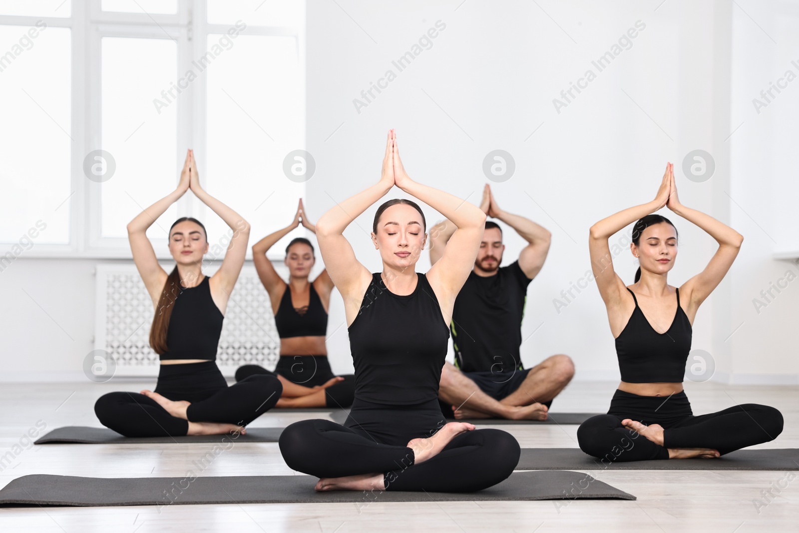 Photo of Group of people meditating on mats in yoga class