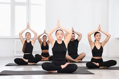 Group of people meditating on mats in yoga class