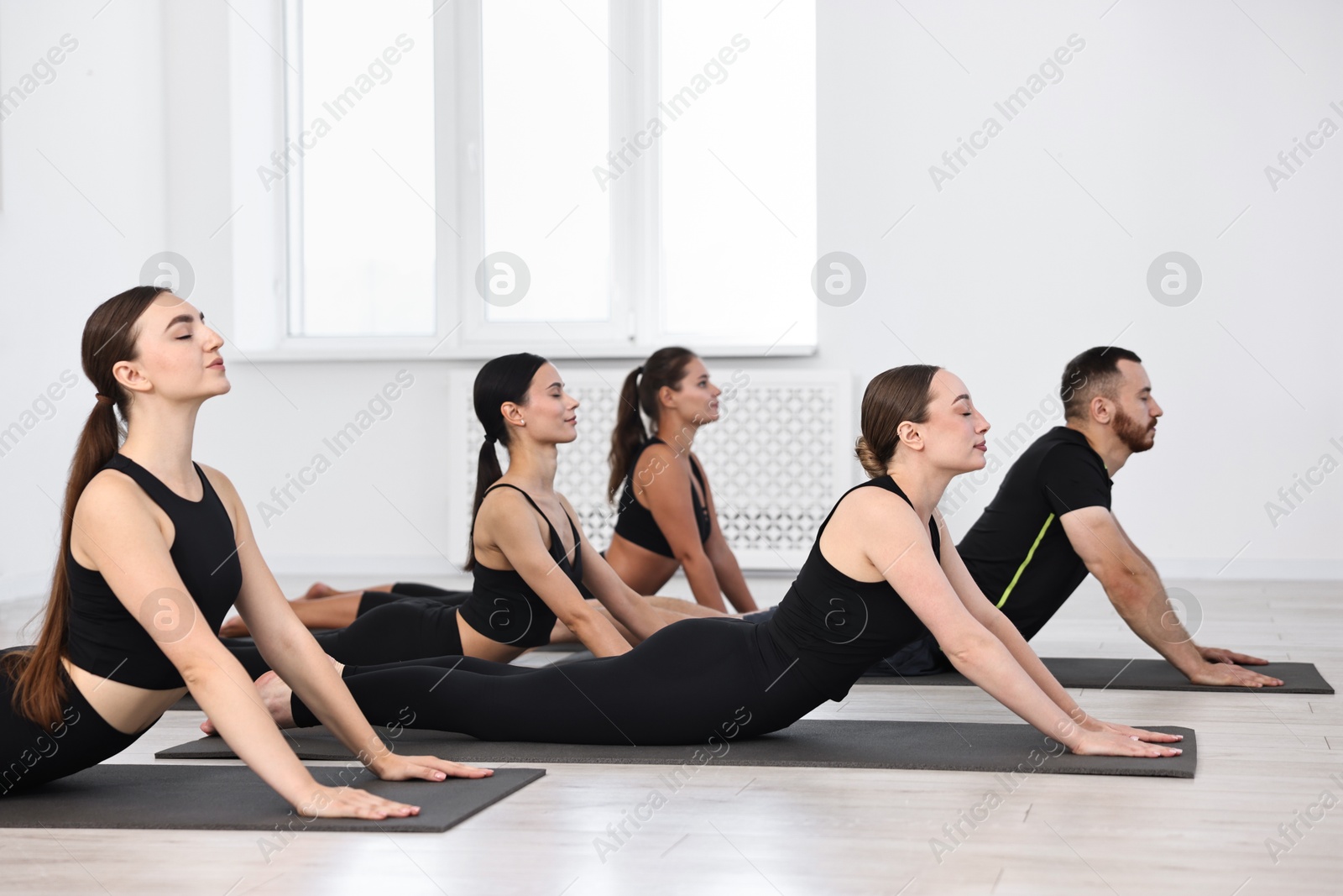 Photo of Group of people practicing yoga on mats in class