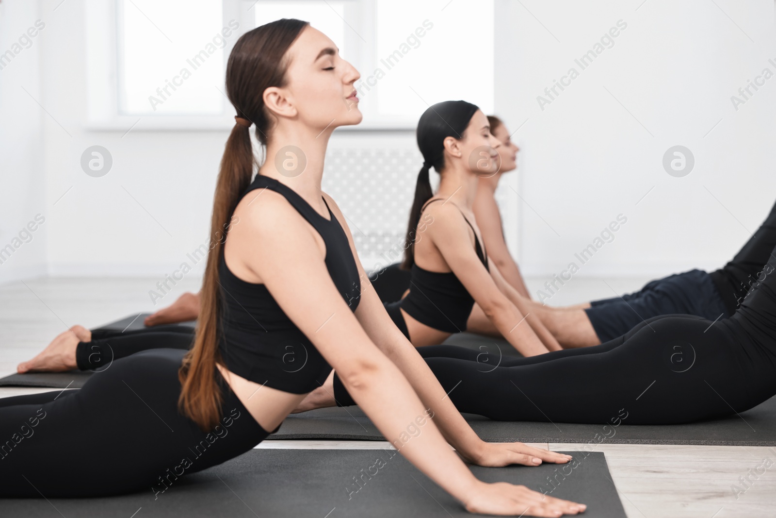 Photo of Group of people practicing yoga on mats in class