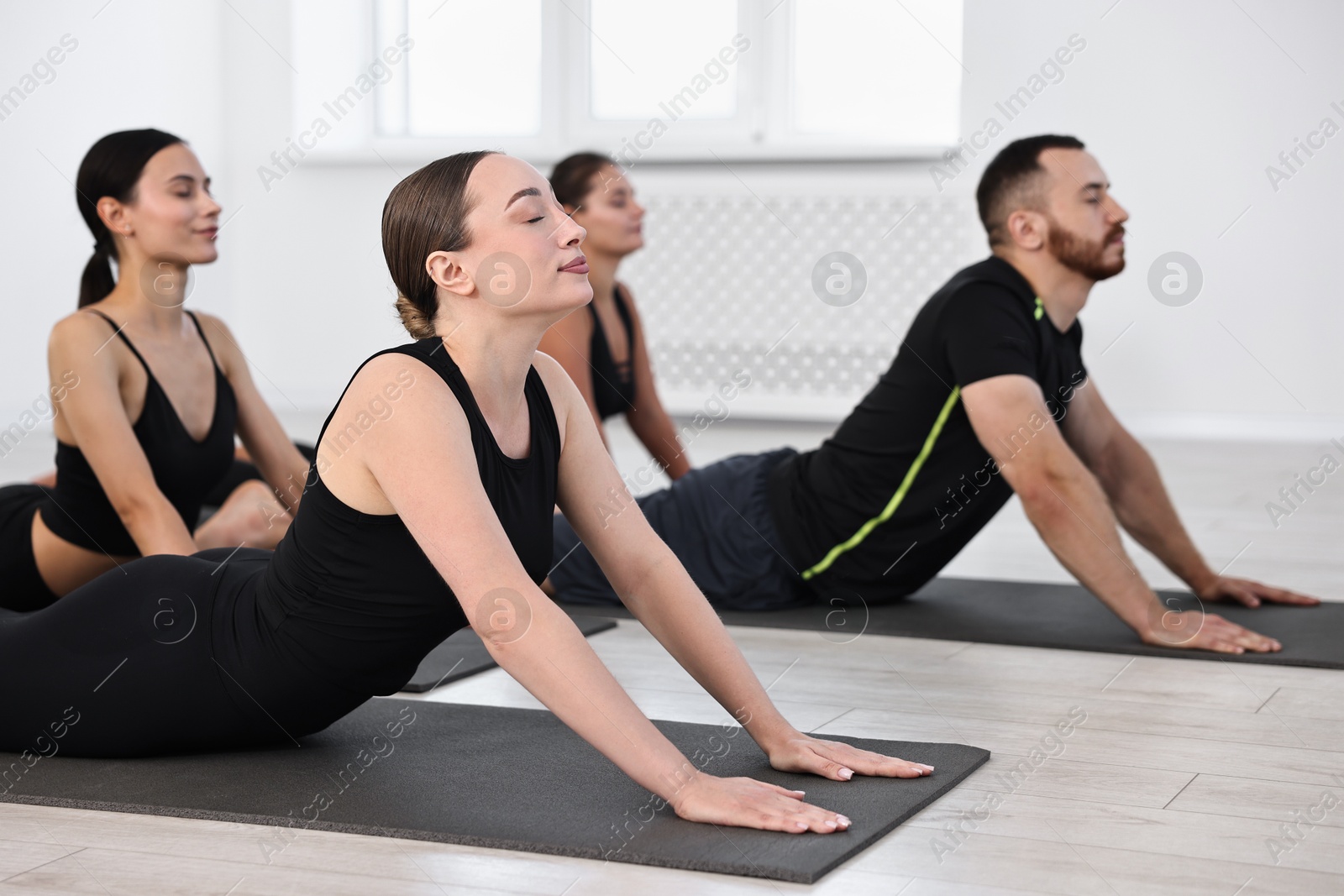 Photo of Group of people practicing yoga on mats in class