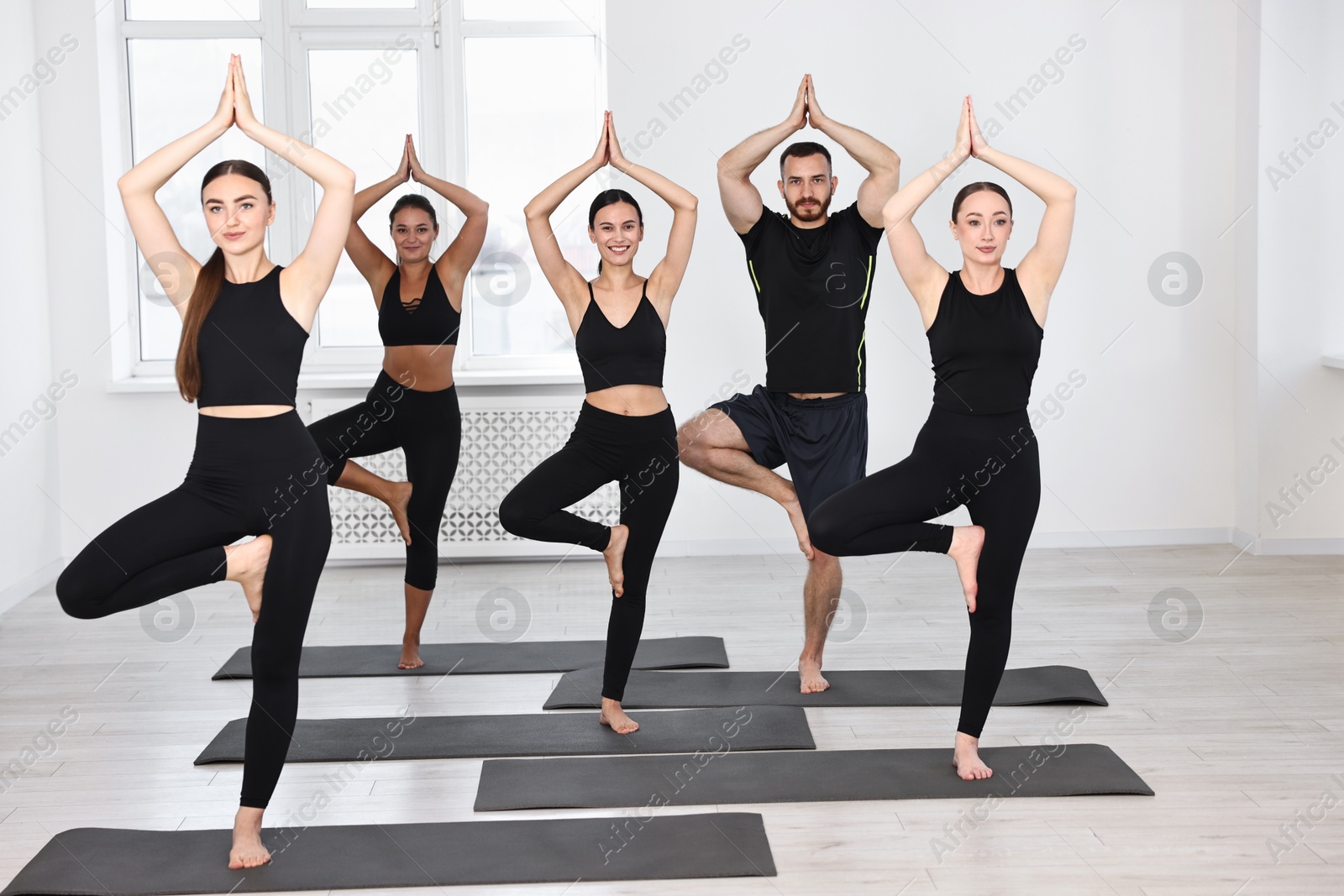 Photo of Group of people practicing yoga on mats in class