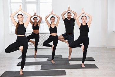 Group of people practicing yoga on mats in class