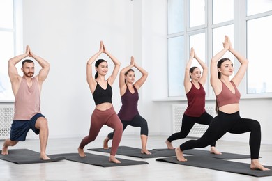 Photo of Group of people practicing yoga on mats in class