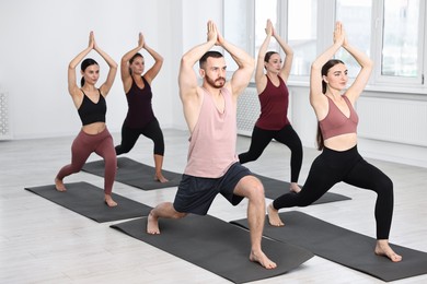 Group of people practicing yoga on mats in class