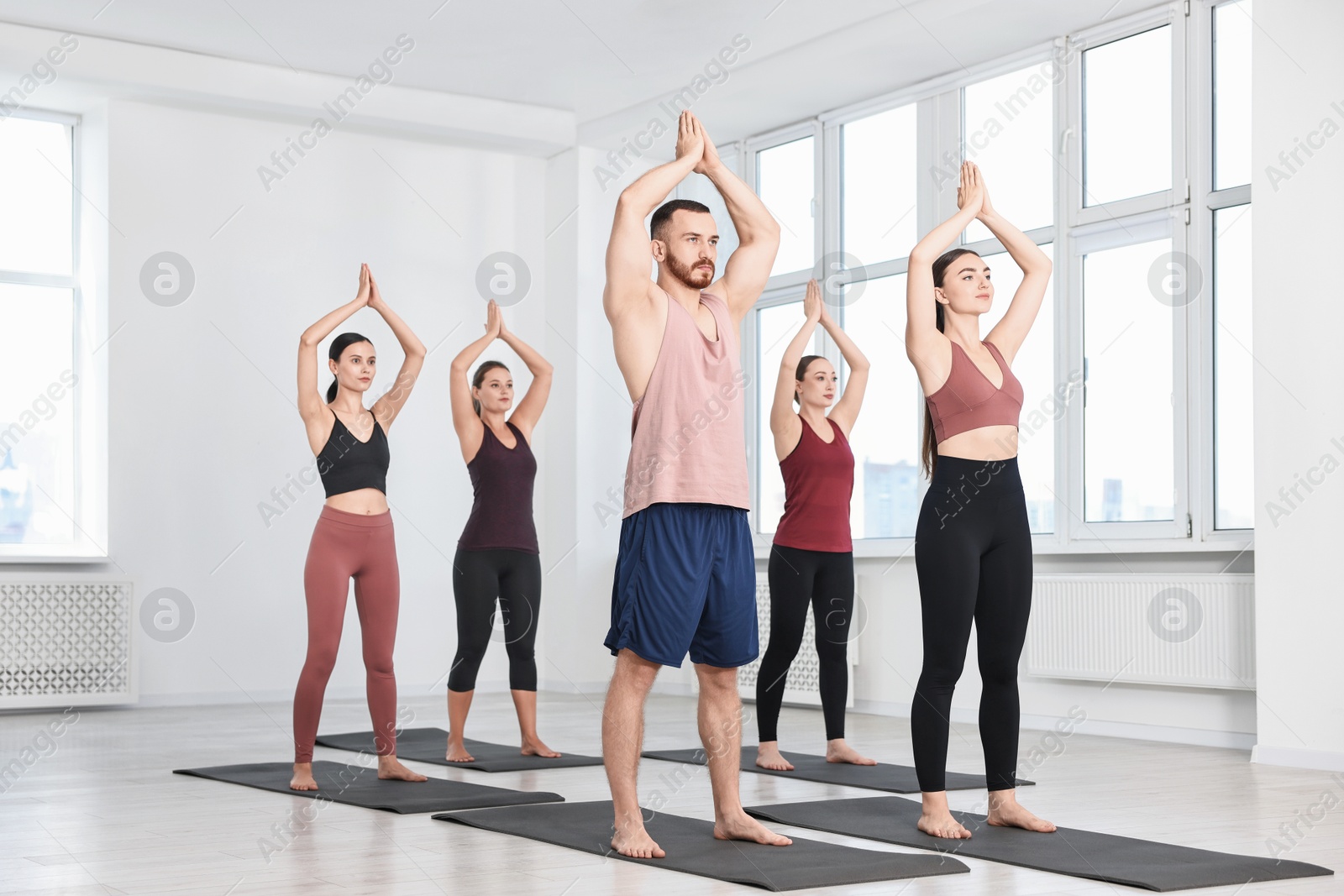 Photo of Group of people practicing yoga on mats in class