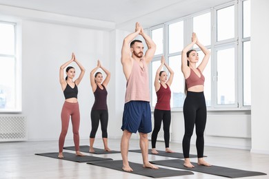 Group of people practicing yoga on mats in class