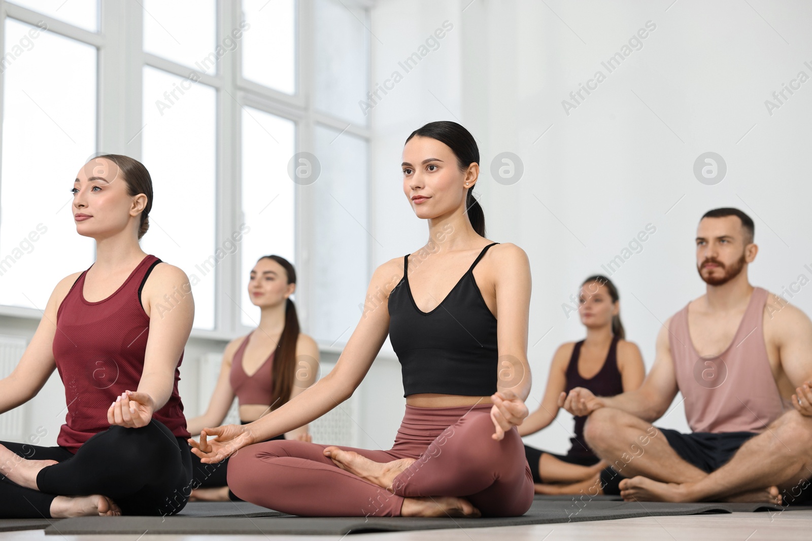 Photo of Group of people meditating on mats in yoga class