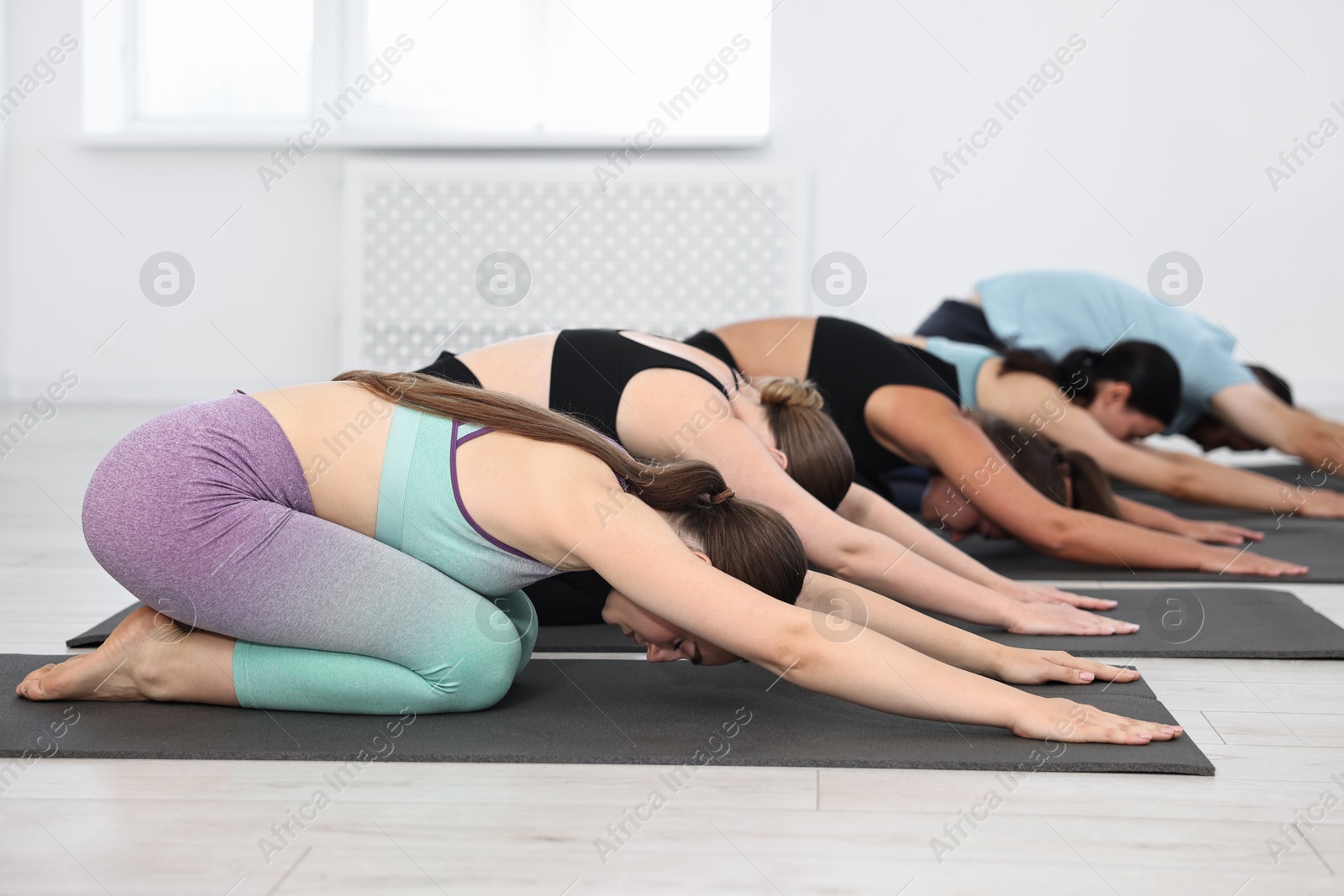 Photo of Group of people practicing yoga on mats in class