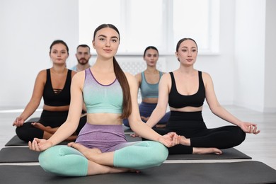 Photo of Group of people meditating on mats in yoga class