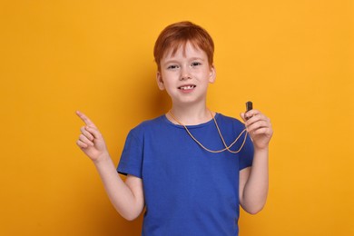 Little boy with whistle on orange background