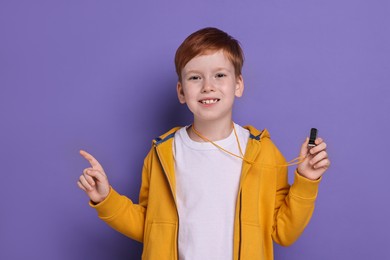 Photo of Little boy with whistle on purple background