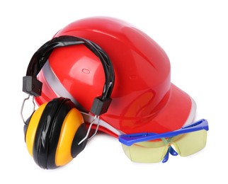 Orange hard hat, earmuffs and goggles isolated on white. Safety equipment