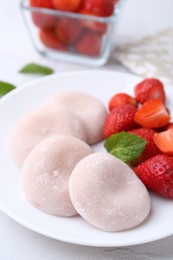 Photo of Delicious mochi and strawberries on table, closeup