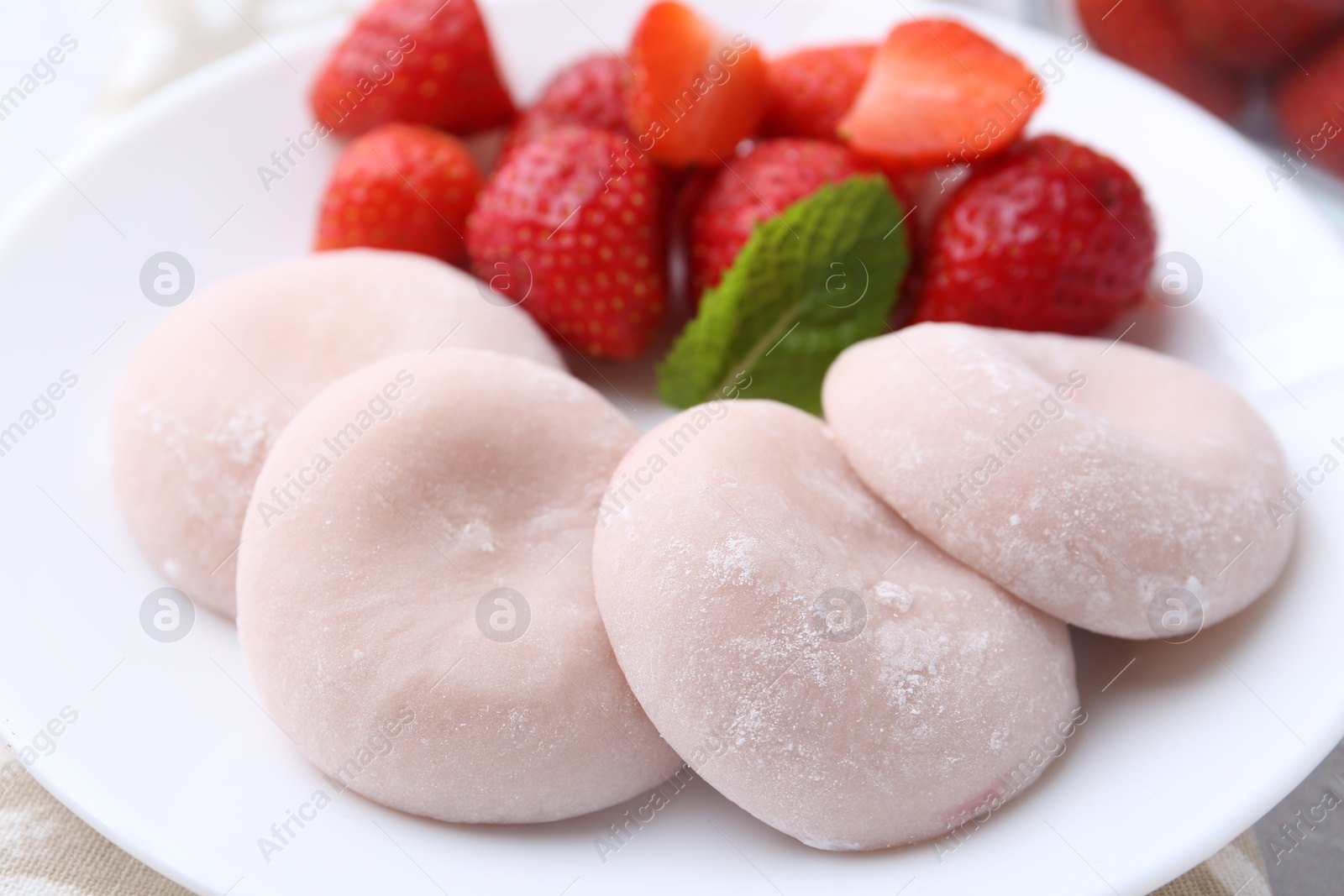 Photo of Delicious mochi and strawberries on table, closeup