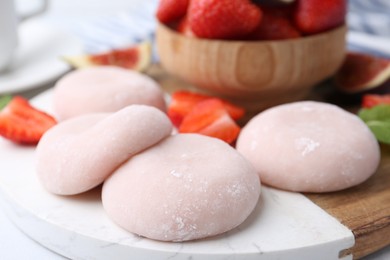 Photo of Delicious mochi and strawberries on table, closeup