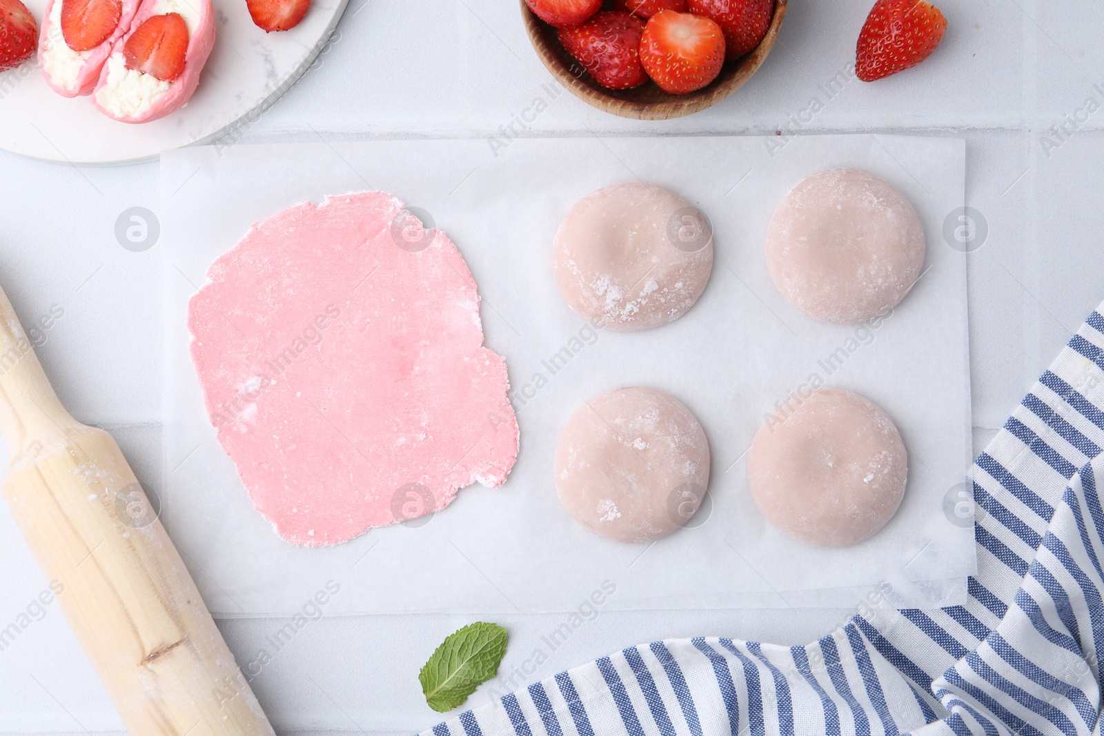 Photo of Tasty homemade mochi, dough and strawberries on white table, top view